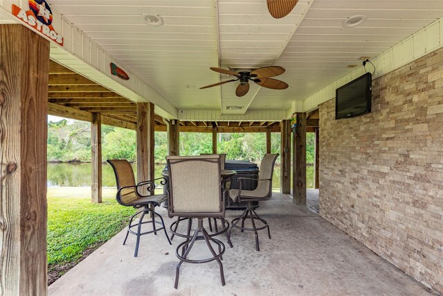 view of patio / terrace with ceiling fan and a water view