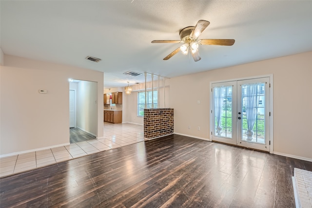 empty room featuring a wealth of natural light, ceiling fan, and light hardwood / wood-style floors