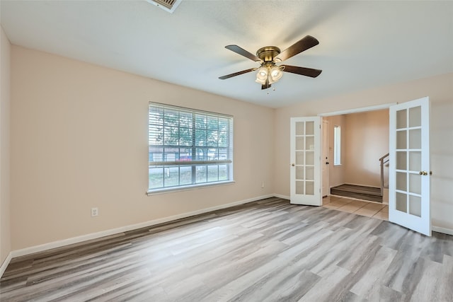 spare room with french doors, light hardwood / wood-style floors, and ceiling fan