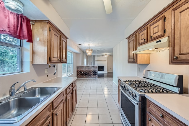 kitchen featuring a healthy amount of sunlight, stainless steel range with gas cooktop, sink, and light tile patterned floors