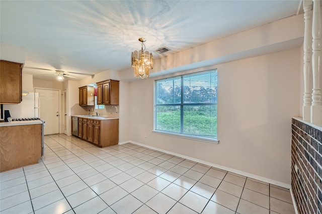 kitchen with pendant lighting, dishwasher, ceiling fan with notable chandelier, sink, and light tile patterned floors