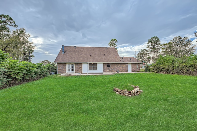 rear view of property with a lawn and french doors