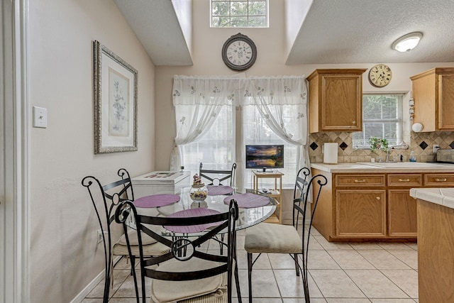 tiled dining space with a textured ceiling and sink