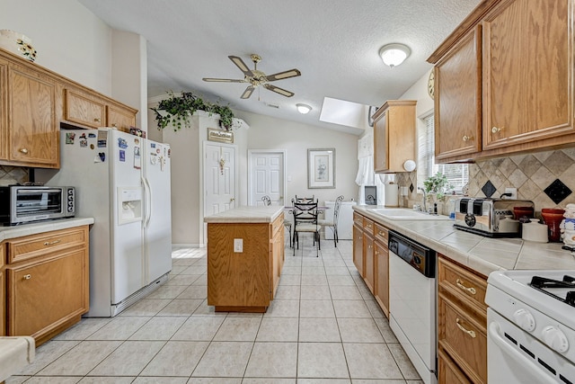 kitchen featuring sink, backsplash, vaulted ceiling, white appliances, and a kitchen island