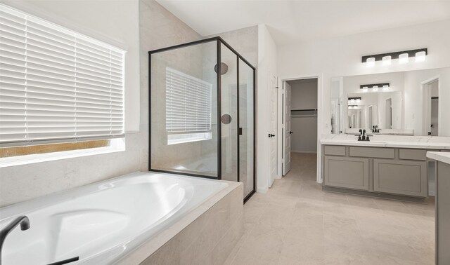 bathroom with tile patterned flooring, vanity, and plus walk in shower