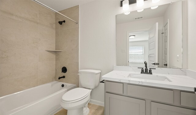 full bathroom featuring vanity, tile patterned floors, toilet, and tiled shower / bath