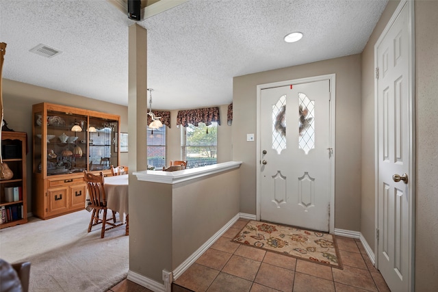 foyer with tile patterned flooring and a textured ceiling