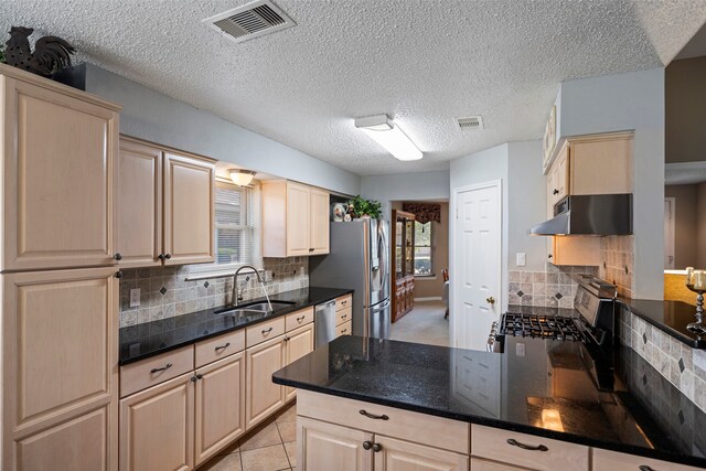 kitchen featuring decorative backsplash, appliances with stainless steel finishes, sink, and light tile patterned floors