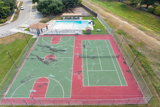 view of basketball court with a fenced in pool