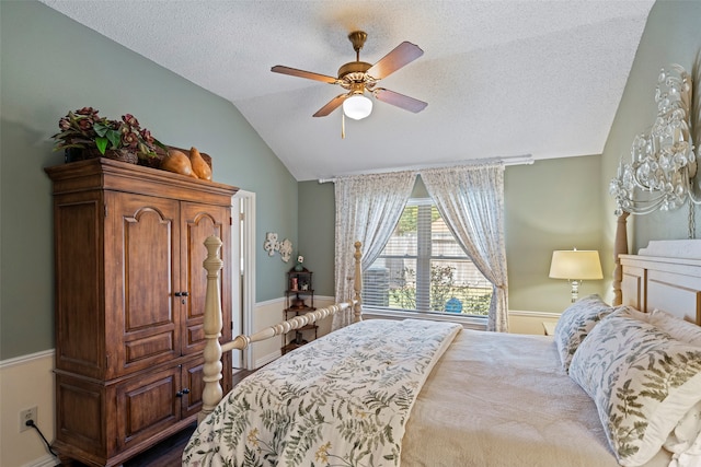 bedroom with lofted ceiling, a textured ceiling, and ceiling fan