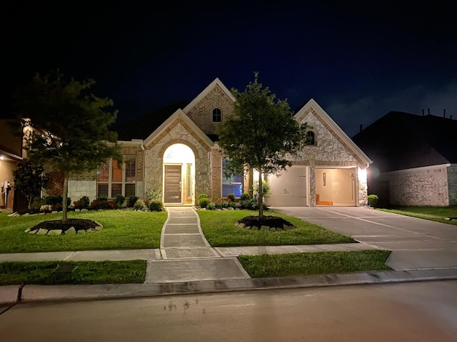 view of front of property with a garage and a lawn