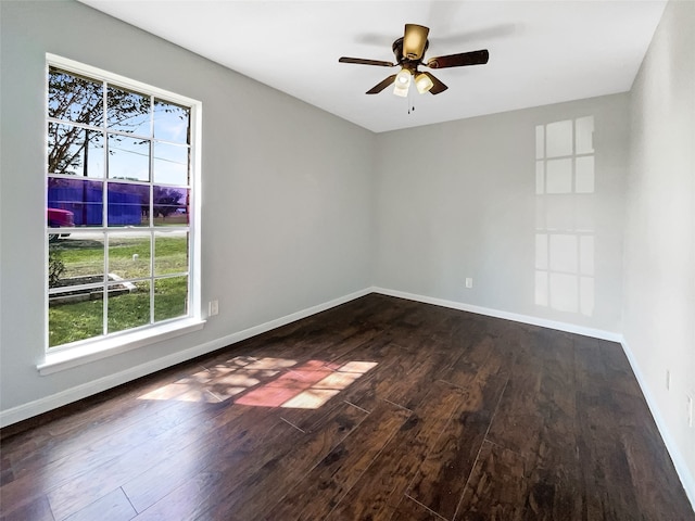 spare room with ceiling fan, a healthy amount of sunlight, and dark hardwood / wood-style flooring