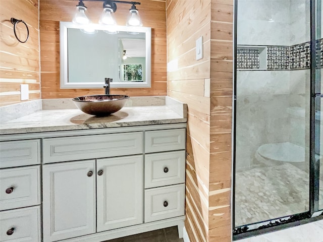 bathroom featuring wood walls, vanity, and an enclosed shower