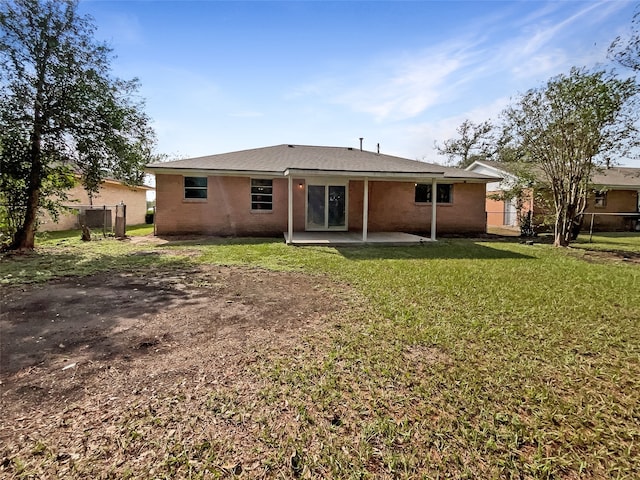 back of property featuring a lawn and a patio