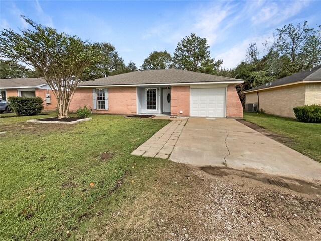 8719 Noble St, Needville, TX 77461 - ranch-style house featuring brick siding, an attached garage, concrete driveway, a front yard, and central AC