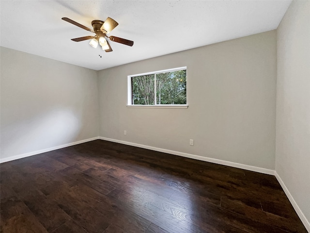 spare room featuring dark wood-type flooring and ceiling fan