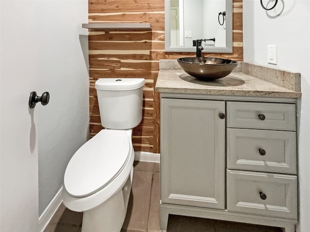 bathroom with wood walls, vanity, and toilet