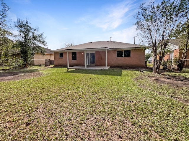 back of property with a yard and a patio