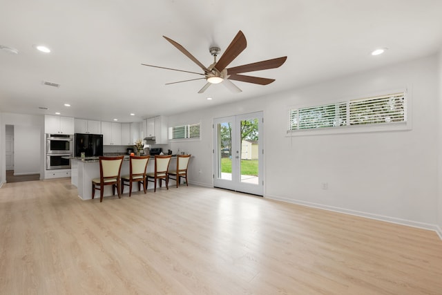 living room with french doors, ceiling fan, and light hardwood / wood-style flooring