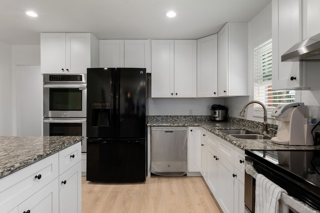 kitchen featuring dark stone countertops, white cabinetry, appliances with stainless steel finishes, and sink