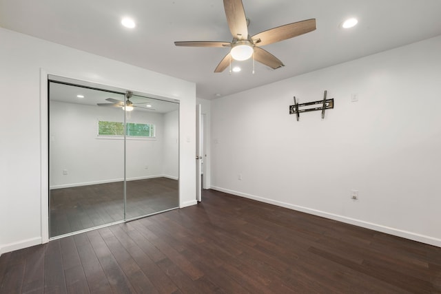 unfurnished bedroom with dark hardwood / wood-style floors, ceiling fan, and a closet