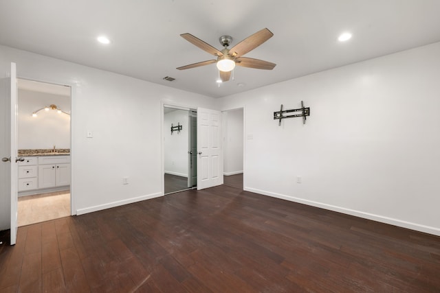 unfurnished bedroom featuring sink, ceiling fan, connected bathroom, a closet, and dark hardwood / wood-style flooring