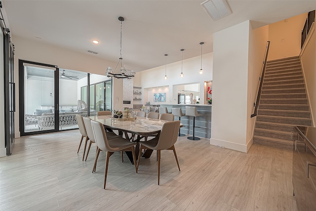 dining space with stairway, an inviting chandelier, visible vents, and light wood-style floors