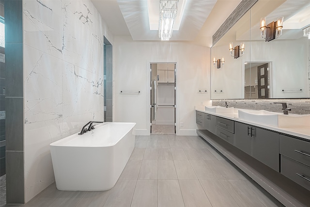 bathroom featuring a freestanding bath, double vanity, a sink, and tile walls