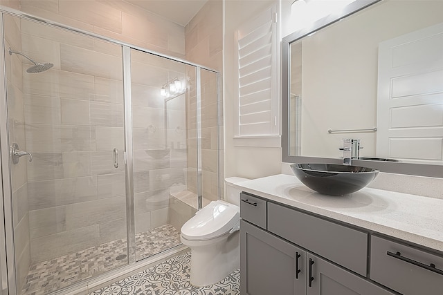 bathroom featuring vanity, toilet, tile patterned floors, and an enclosed shower