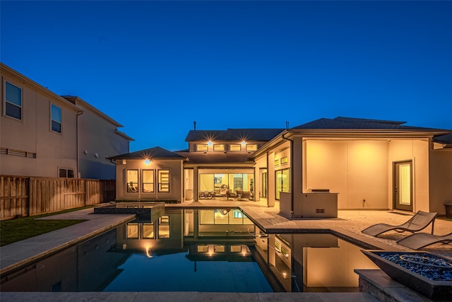 back of house with a fenced in pool, a fire pit, and a patio