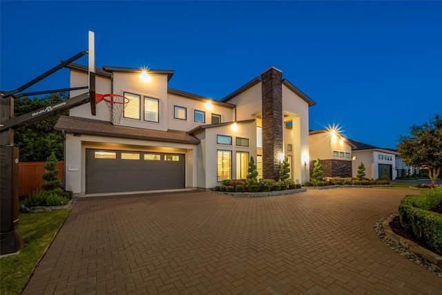 view of front of home featuring a garage, decorative driveway, and stucco siding