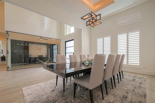 dining room with a chandelier, a high ceiling, wood finished floors, and baseboards