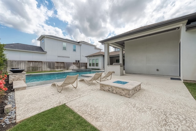 view of swimming pool with a fire pit, a patio area, and pool water feature