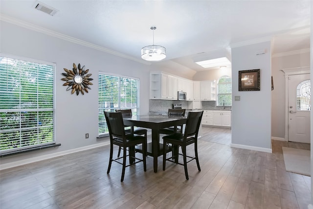 dining room with a chandelier, wood-type flooring, and crown molding