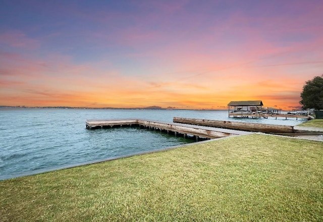 dock area with a water view and a yard