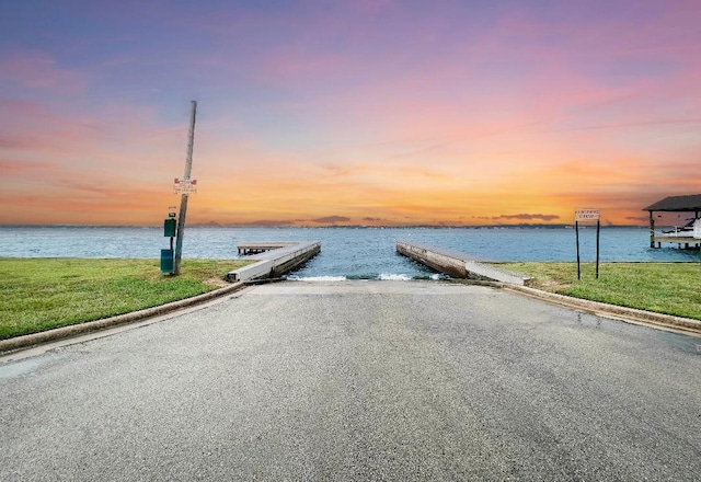 dock area featuring a water view and a yard