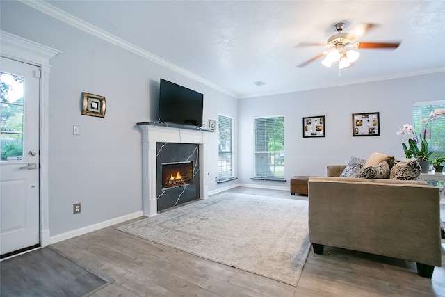 living room with a fireplace, wood-type flooring, ceiling fan, and ornamental molding