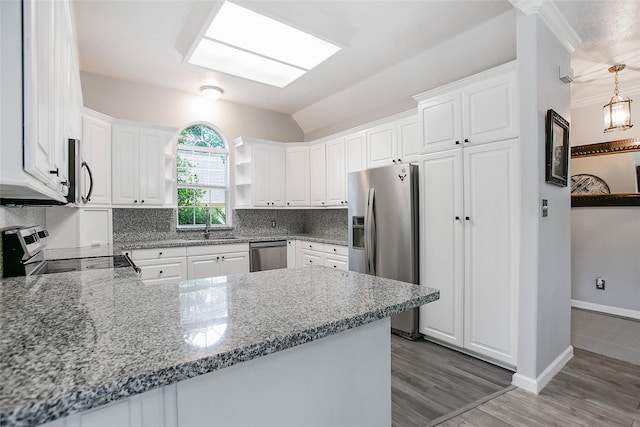 kitchen with stainless steel appliances, white cabinets, and kitchen peninsula