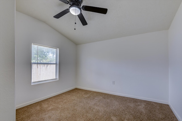 carpeted empty room with ceiling fan and vaulted ceiling