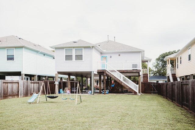 back of property featuring a playground and a yard