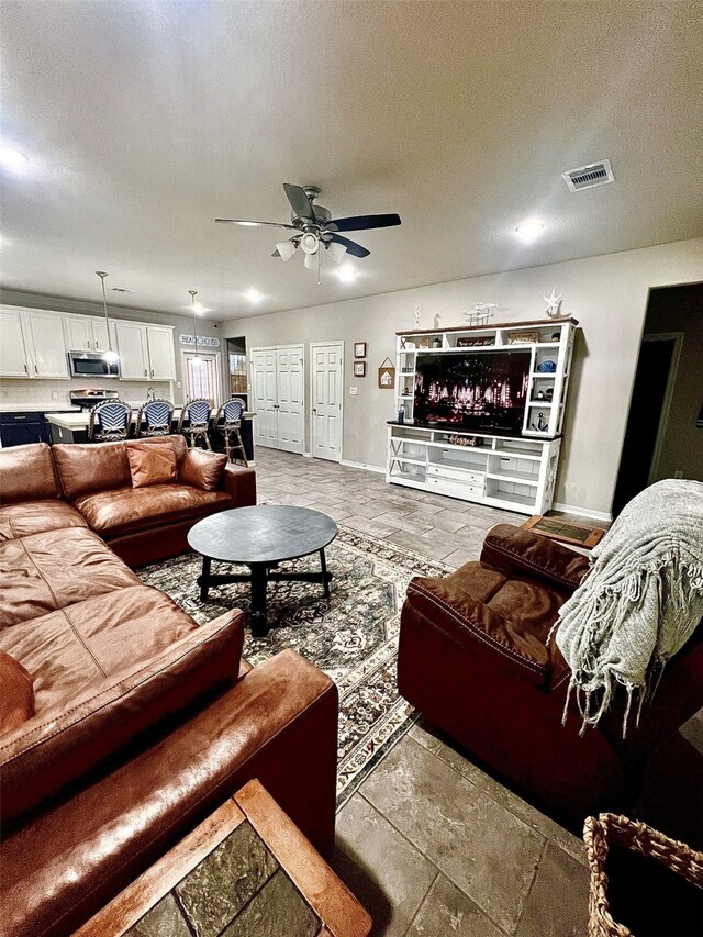 living room featuring a textured ceiling and ceiling fan