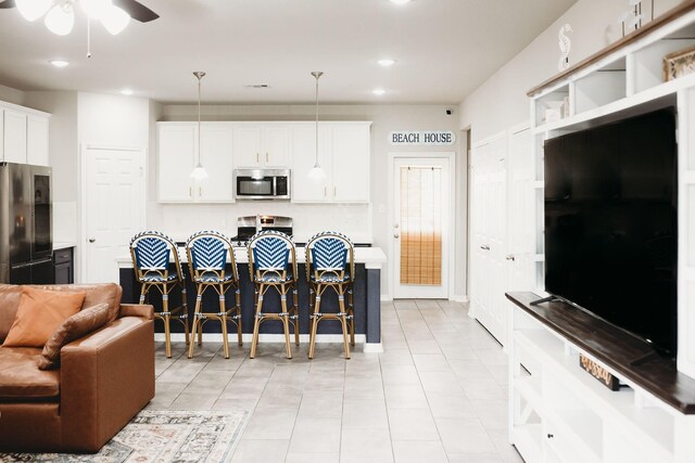 kitchen featuring white cabinets, appliances with stainless steel finishes, hanging light fixtures, and ceiling fan