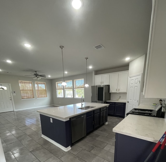 kitchen with white cabinets, hanging light fixtures, ceiling fan, an island with sink, and stainless steel appliances