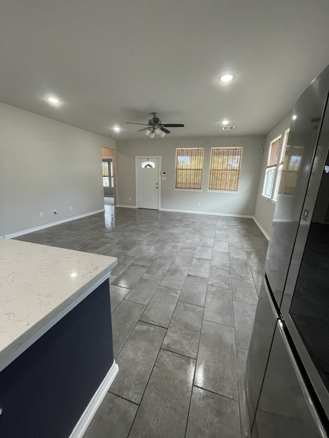 unfurnished living room with ceiling fan