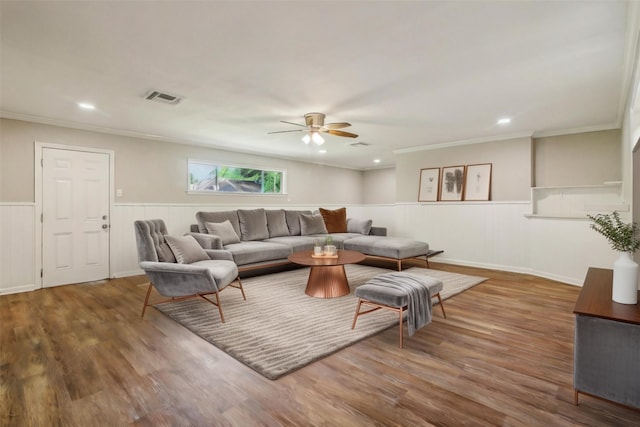 living room with wood-type flooring, ceiling fan, and crown molding