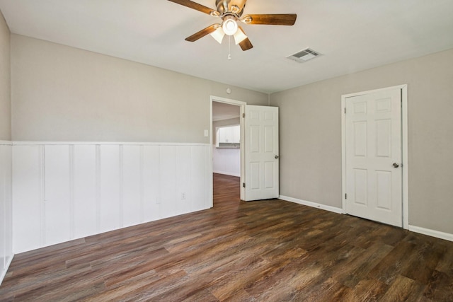 unfurnished room featuring ceiling fan and dark wood-type flooring