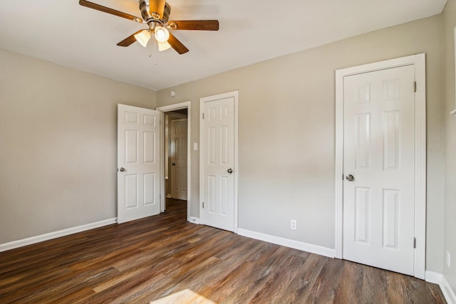 unfurnished bedroom featuring ceiling fan and dark wood-type flooring