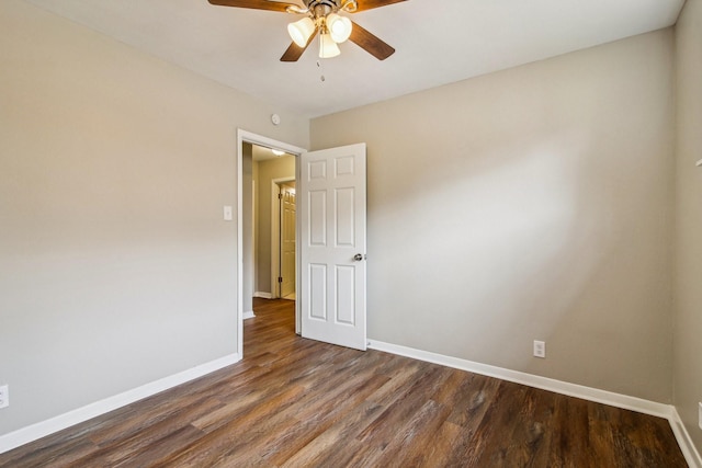 spare room featuring ceiling fan and dark wood-type flooring