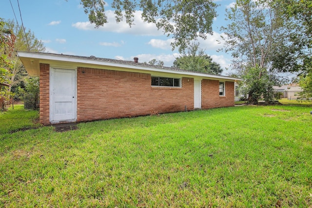 rear view of house featuring a yard