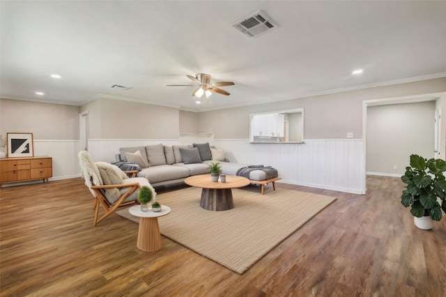 living room with wood-type flooring, ceiling fan, and ornamental molding